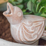 terracotta bird watering spike sculpture with intricate designs on a natural background