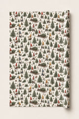 Tree Harvest Christmas gnome wrapping paper roll with colourful gonks, fir trees and sledges on a snowy pale background.