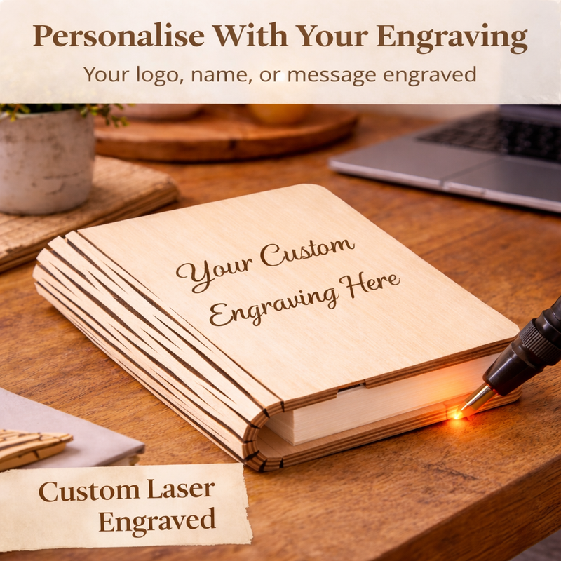 Wooden notebook being engraved with a laser on a wooden table, with text about personalization.