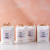 Four 'Shell on Earth' packages with floral designs on a pink background