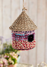 Woven birdhouse with colorful pattern on a blurred background
