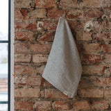 Gray towel hanging on a brick wall