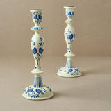 Two wood candle holders with blue floral patterns on a beige background