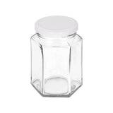 Hexagonal glass jar with a white lid on a white background