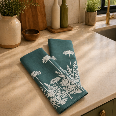 Linen tea towel with white floral design on a kitchen counter
