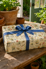 Gift wrapped in Watering Cans & Wildflowers Wrapping Paper  in Warm Ivory  patterned with watercolour watering cans, wildflowers and garden tools.