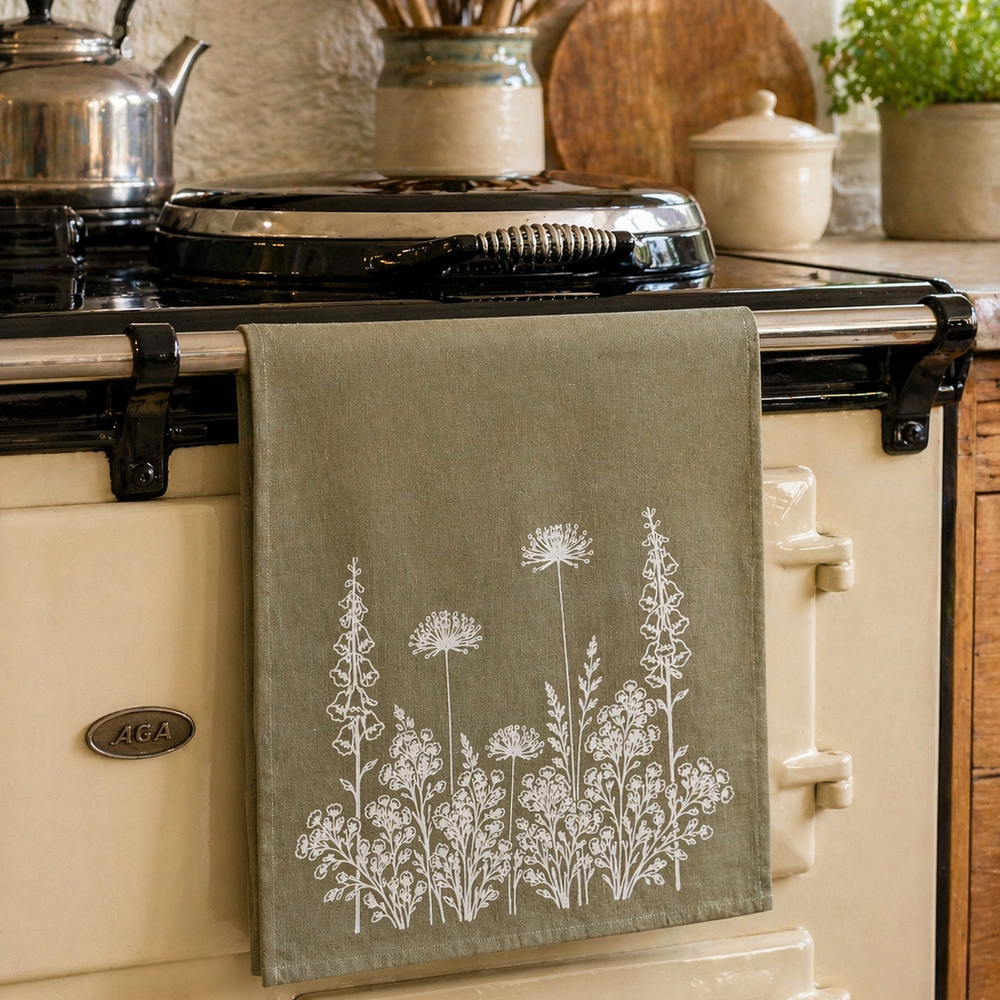 Kitchen scene with a vintage stove, hand printed tea towel in sage green with white floral design.
