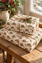 Stacked hedgehog Christmas parcels with natural twine beside a bright cottage window.