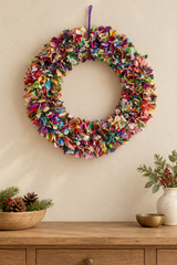 Colourful handmade sari wreath displayed on a wall