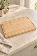Blank 60 × 40cm rubberwood butcher’s block with a recessed border on a pale kitchen worktop beside a linen cloth.