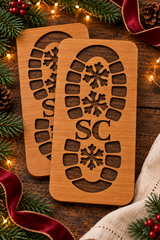 Pair of wooden Santa boot stencils with snowflake tread and SC cut-outs, styled for Christmas.