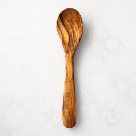 olive wood wooden spoons and cutting board with kitchen items.