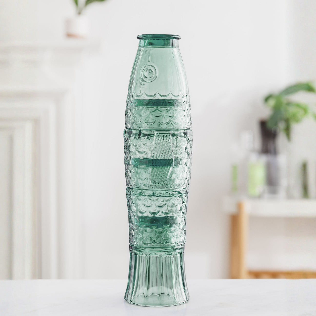 set of 4 Decorative green stacking fish glasses on a white surface with a blurred indoor background