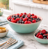 Bowl of mixed berries on a marble countertop with a kitchen setting.