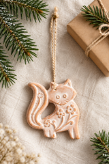Terracotta fox ornament with jute loop on a festive flat lay