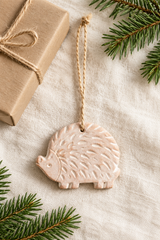 Handmade hedgehog ornament with jute loop in a festive flat lay