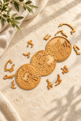 Original Three Rings wooden tessellation puzzle and loose pieces on pale limestone beside oatmeal linen.