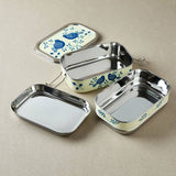 Set of stainless steel lunch boxes with floral designs on a beige background