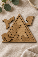 Close-up of a partly assembled Triangle puzzle on linen, showing oak veneer, angular pieces and thin dark edges.