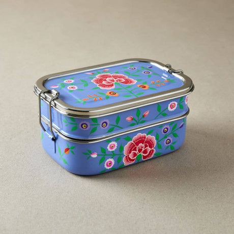 Tiffin tin metal lunch box with floral design on a beige background