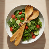 Wooden salad servers tied with a ribbon on a white background