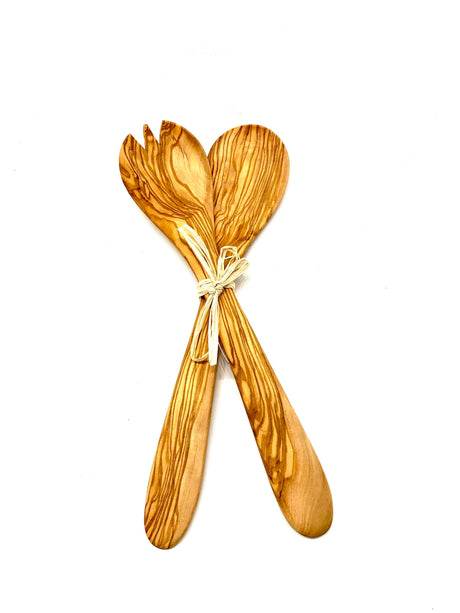 Wooden salad servers tied together on a white background