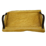 Solid oak serving tray with gently waney edges on both sides and leather handles engraved with a floral pattern. Handles are secured with metal studs.